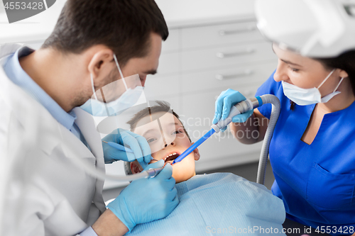 Image of dentist treating kid teeth at dental clinic