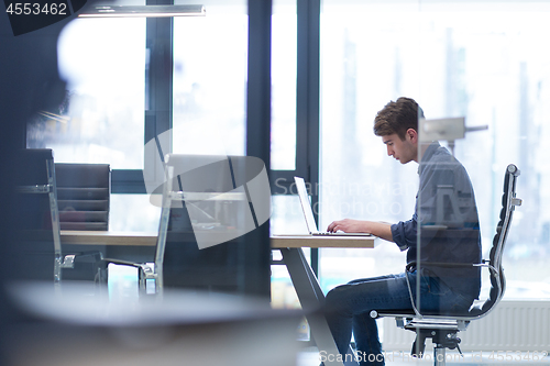 Image of businessman working using a laptop in startup office