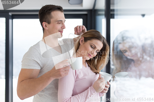 Image of young couple enjoying morning coffee by the window