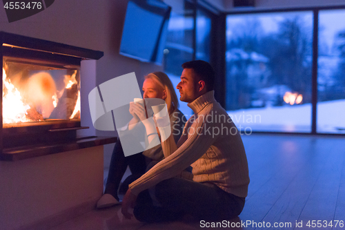 Image of happy couple in front of fireplace