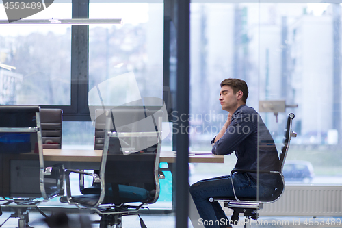 Image of young businessman relaxing at the desk