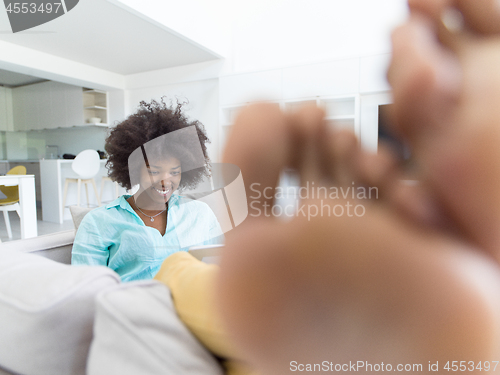 Image of african american woman at home using digital tablet