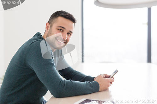 Image of Young casual businessman using smartphone