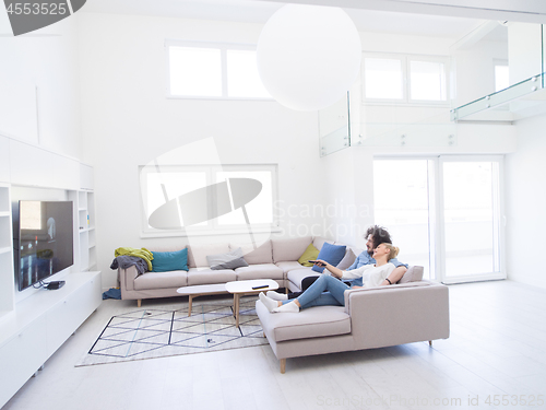 Image of Young couple on the sofa watching television