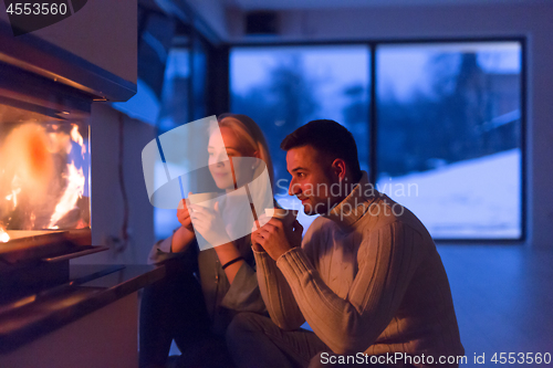 Image of happy couple in front of fireplace