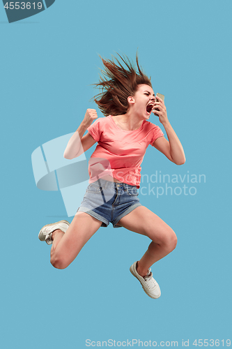 Image of Full length of pretty young woman with mobile phone while jumping