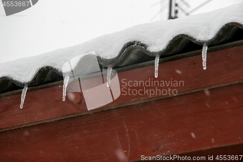 Image of Brown house roof with icicles.