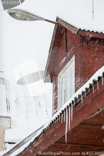 Image of Brown house roof with icicles.