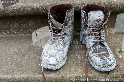 Image of Dirty old workboots on stairs.