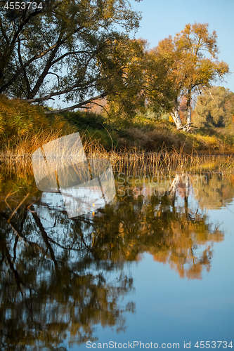 Image of Autumn landscape with colorful trees and reflection in river. 