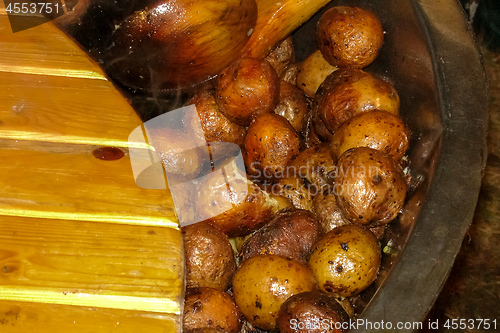 Image of Potatoes with peel in pan in outdoor. 