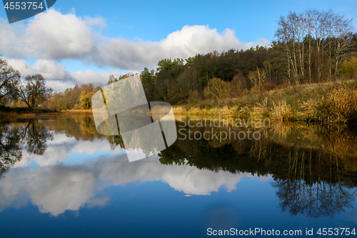 Image of Autumn landscape with colorful trees and river. Reflection in ri