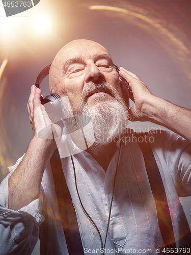 Image of elderly bald head man with headphones