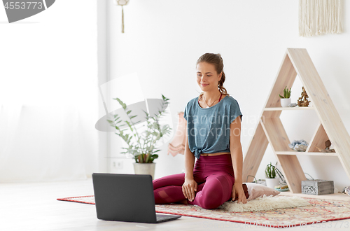 Image of woman with laptop computer at yoga studio