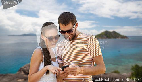 Image of happy couple with smartphone on seychelles island