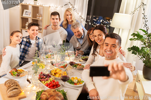 Image of family having dinner party and taking selfie