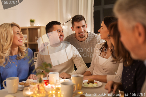 Image of happy family having tea party at home