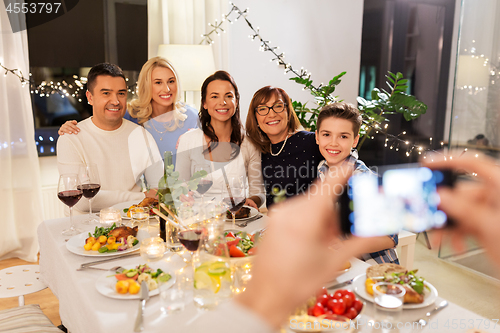 Image of family photographing by smartphone at dinner party