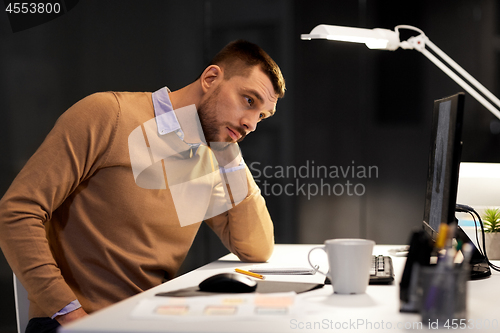 Image of man with computer working late at night office