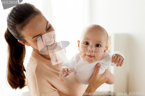 Image of happy mother playing with little baby boy at home