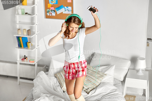 Image of happy woman in headphones having fun at home