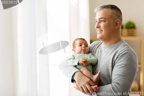 Image of happy father holding with little baby son at home