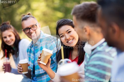 Image of friends drinking coffee and juice talking in city