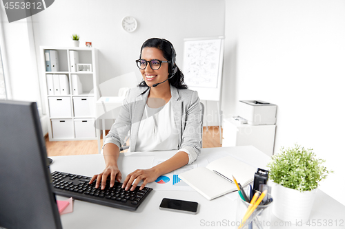 Image of businesswoman with headset and computer at office
