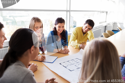 Image of group of smiling students with blueprint