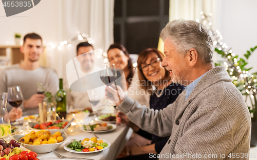 Image of happy family having dinner party at home