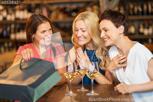 Image of women with shopping bag at wine bar or restaurant
