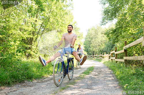 Image of happy couple with bicycles at summer park