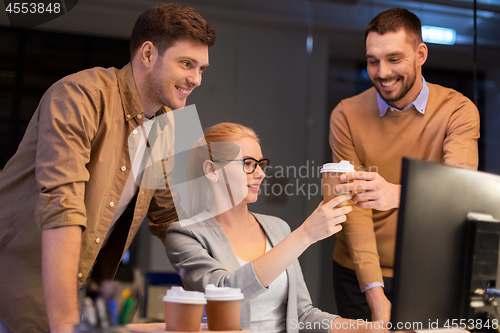 Image of business team with coffee working at night office