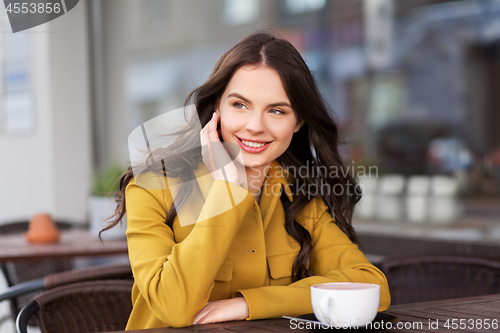 Image of teenage girl drinking hot chocolate at city cafe