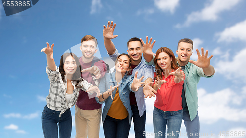 Image of group of happy students over blue sky background