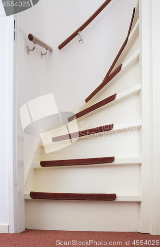 Image of White wooden stairs with red mats