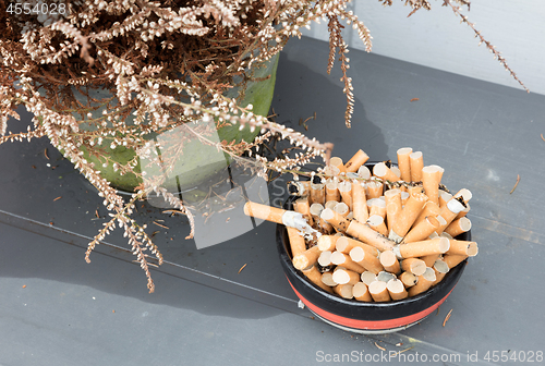 Image of Overflowing ashtray, chain smoking