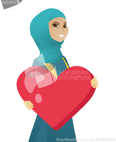 Image of Young muslim business woman holding a big heart.