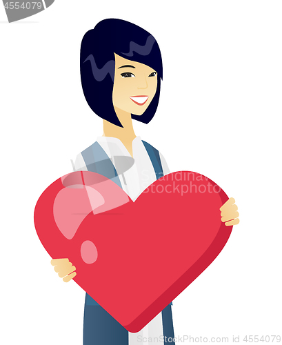 Image of Young asian business woman holding a big heart.