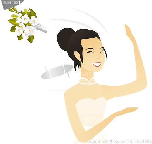 Image of Young asian bride tossing a bouquet of flowers.