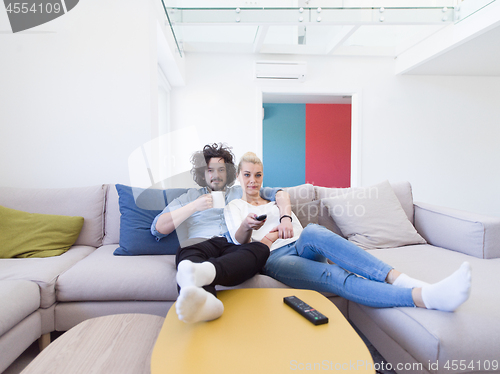 Image of Young couple on the sofa watching television