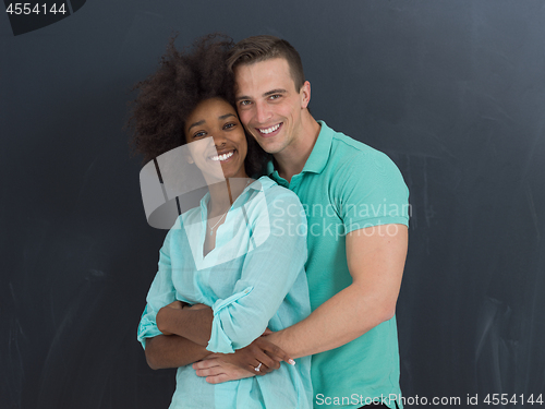 Image of multiethnic couple in front of gray chalkboard