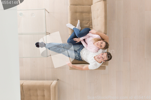 Image of Young couple on the sofa watching television top view