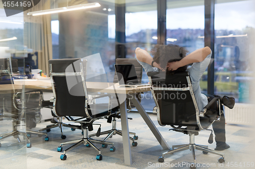 Image of young businessman relaxing at the desk