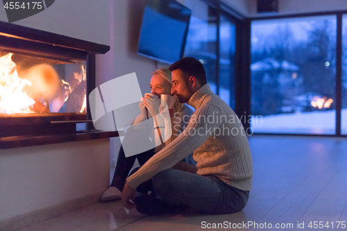 Image of happy couple in front of fireplace