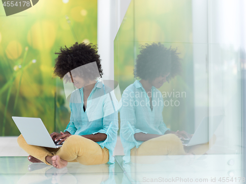 Image of black women using laptop computer on the floor