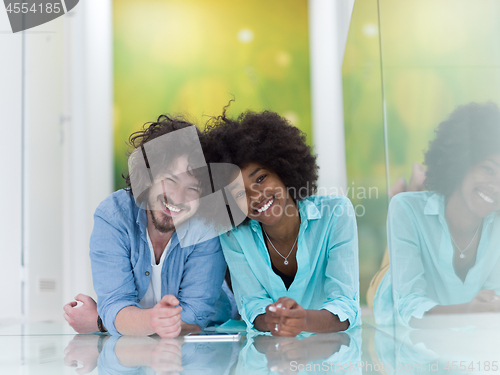 Image of Couple relaxing together at home with tablet computer