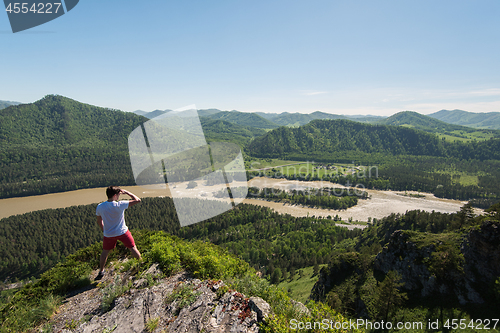 Image of Man standing on top of cliff