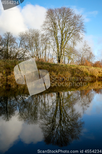 Image of Autumn landscape with colorful trees and river. Reflection in ri