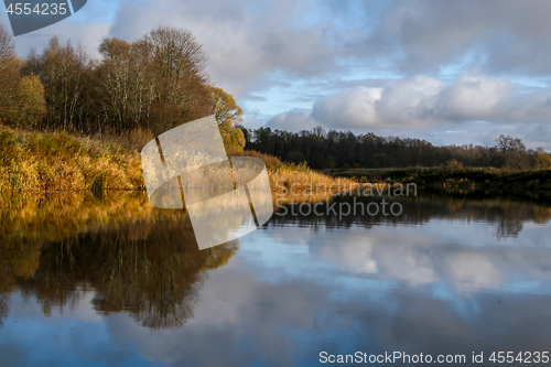 Image of Autumn landscape with colorful trees and river. Reflection in ri